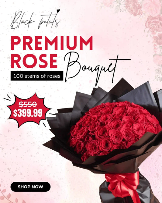Premium rose bouquet with 100 red rose stems wrapped in black paper and red ribbon, on pink background