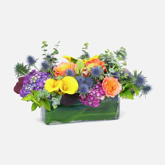On Holiday Arrangement with roses, ranunculus, hydrangeas, and thistles in bright colors, available for same-day delivery in Manhattan & NYC.