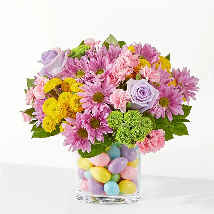 Easter flowers NYC bouquet with pastel roses, daisies, and colorful eggs in glass vase, perfect for same-day delivery Manhattan