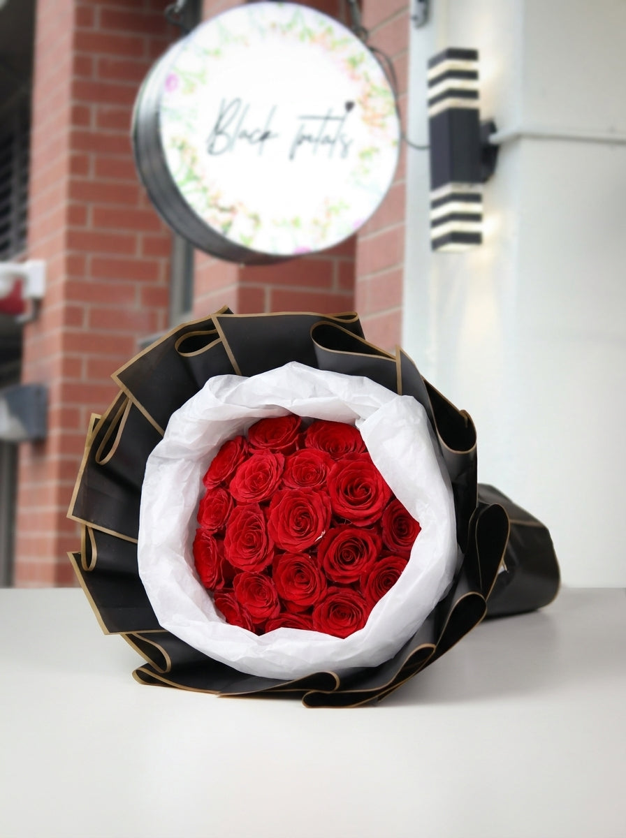 Premium 24 stem red rose bouquet featuring twenty-four fresh long-stem red roses wrapped in elegant black and white premium paper, creating a timeless romantic gift for anniversaries, Valentine's Day, proposals, birthdays, and special occasions.