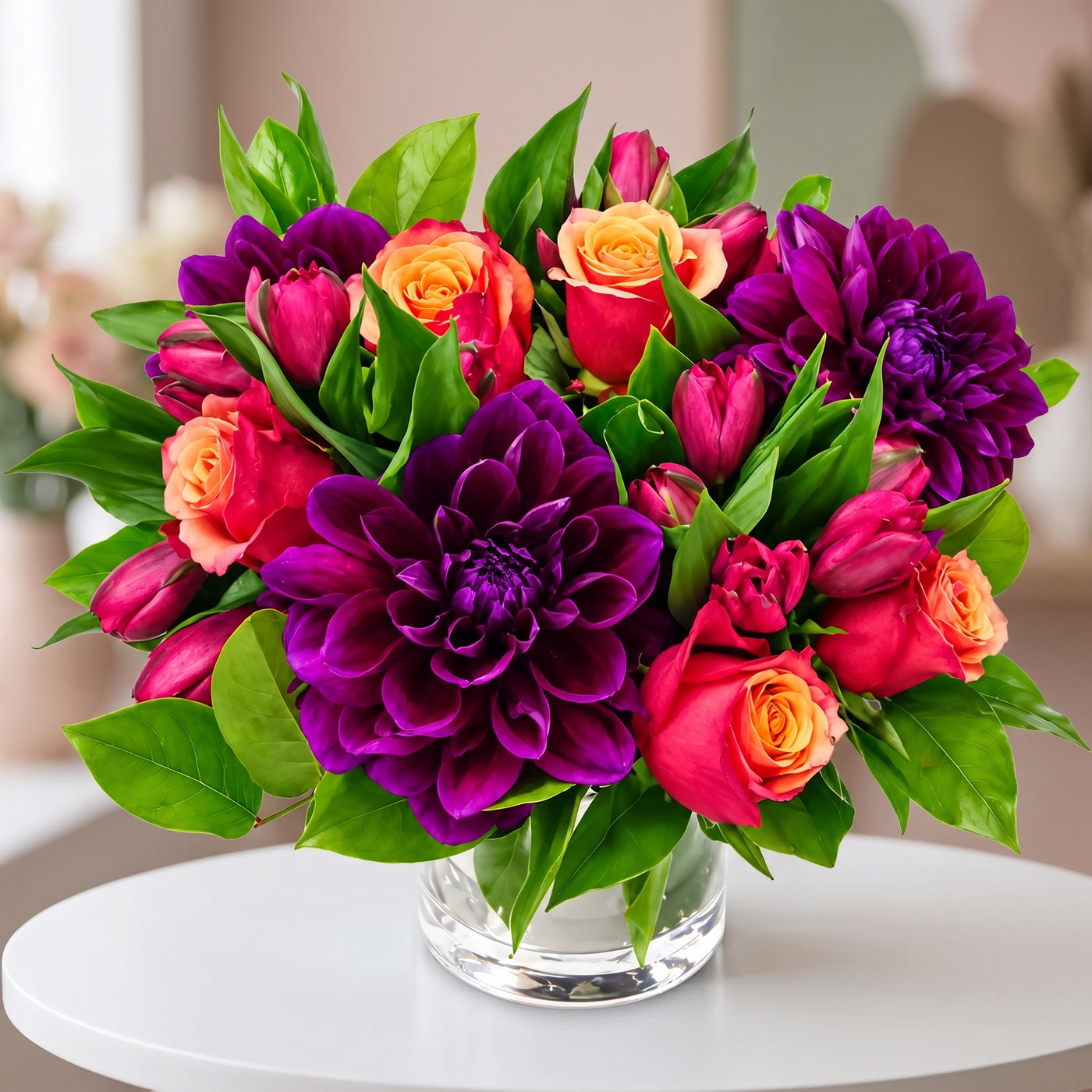 Purple dahlia arrangement with pink tulips, coral roses and lush green foliage