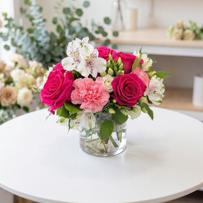 Hot pink rose floral arrangement with carnations and white alstroemeria in clear glass vase