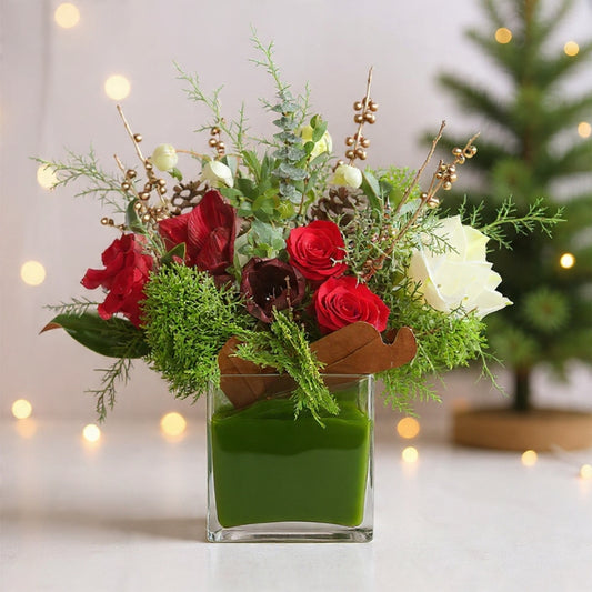 Red and white roses with hydrangeas, cedar, and eucalyptus arranged neatly in a modern square holiday floral box centerpiece.