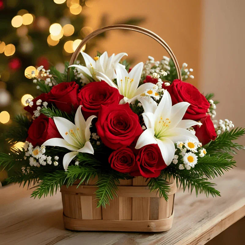 Christmas flower basket with red roses, white lilies, daisies, and green foliage on wooden table