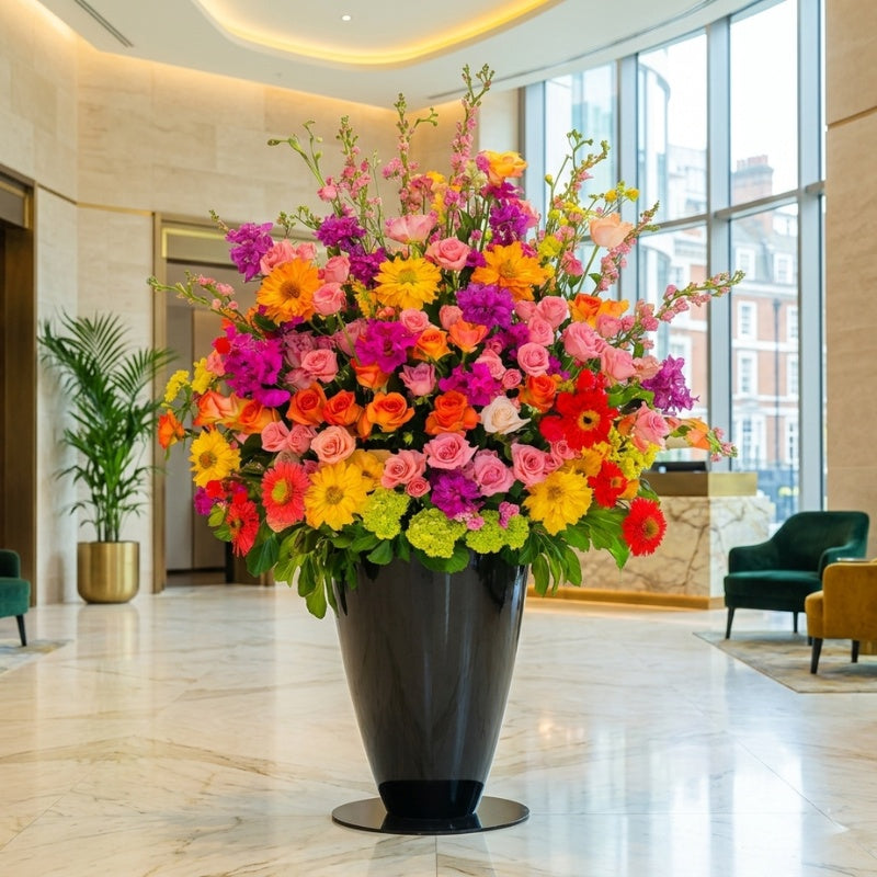 Vibrant Executive Floral Display by Black Petals featuring premium roses, gerbera daisies, stock, snapdragons, and seasonal flowers in a modern black vase for hotel lobbies, corporate offices, and commercial spaces.