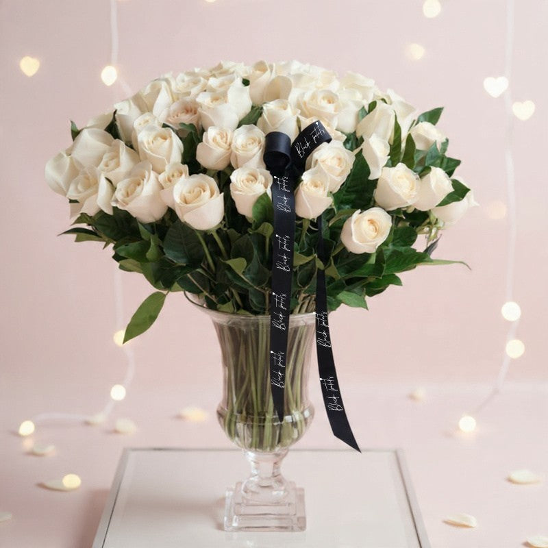 Ivory white rose arrangement in a clear glass vase