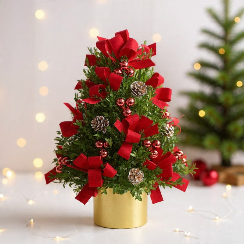 Mini Christmas tree with red bows, ornaments, and pinecones arranged in a gold base, perfect for festive holiday décor and gifting.