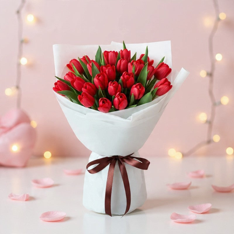 Classic red tulip bouquet wrapped in white paper with ribbon