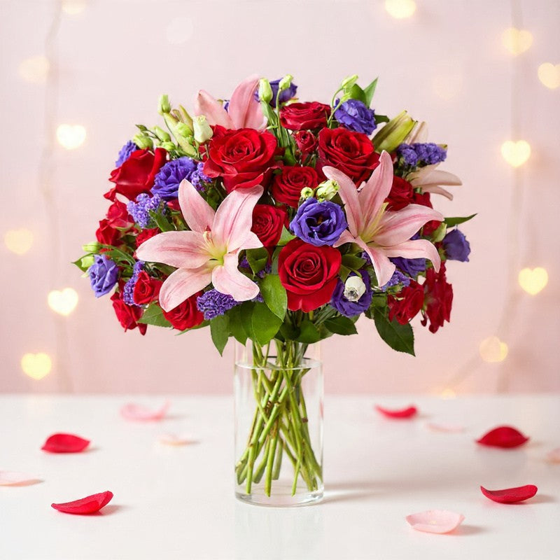 Truly Stunning bouquet with red roses, pink lilies, and purple flowers in a glass vase