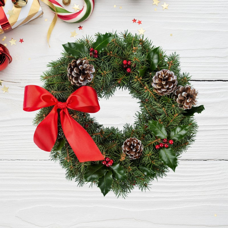 Holly Pine Christmas Wreath with red ribbon, pinecones, holly leaves, and berries for classic holiday home and doorway décor.