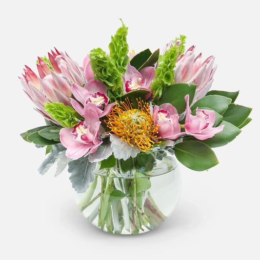 Hawaiian Hues Arrangement with pink proteas, golden pincushions, and tropical greenery, available for same-day delivery in Manhattan & NYC.