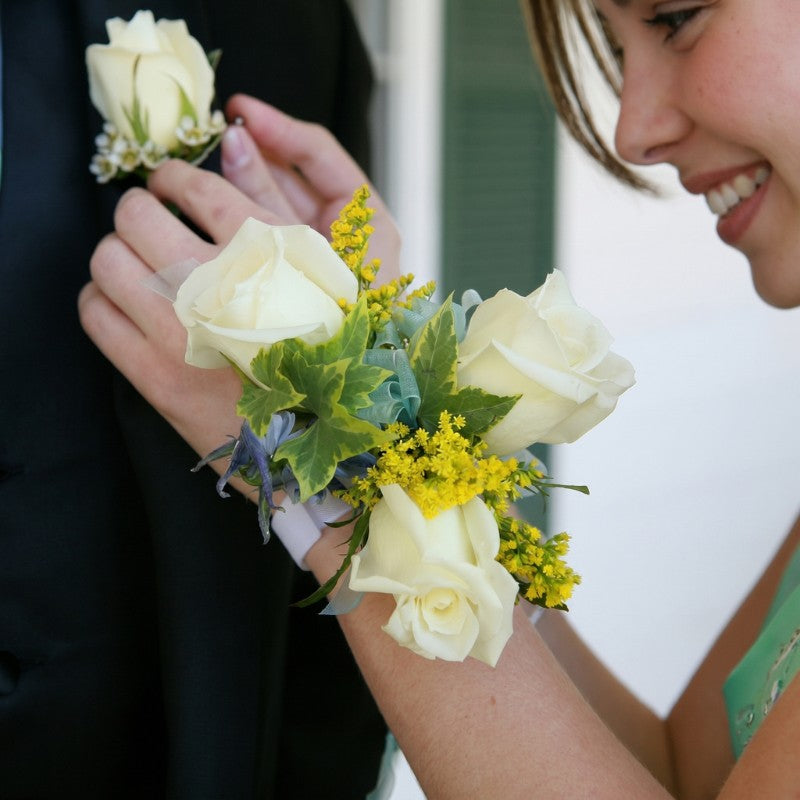 Classic white rose prom flowers with yellow filler blooms and green ivy details